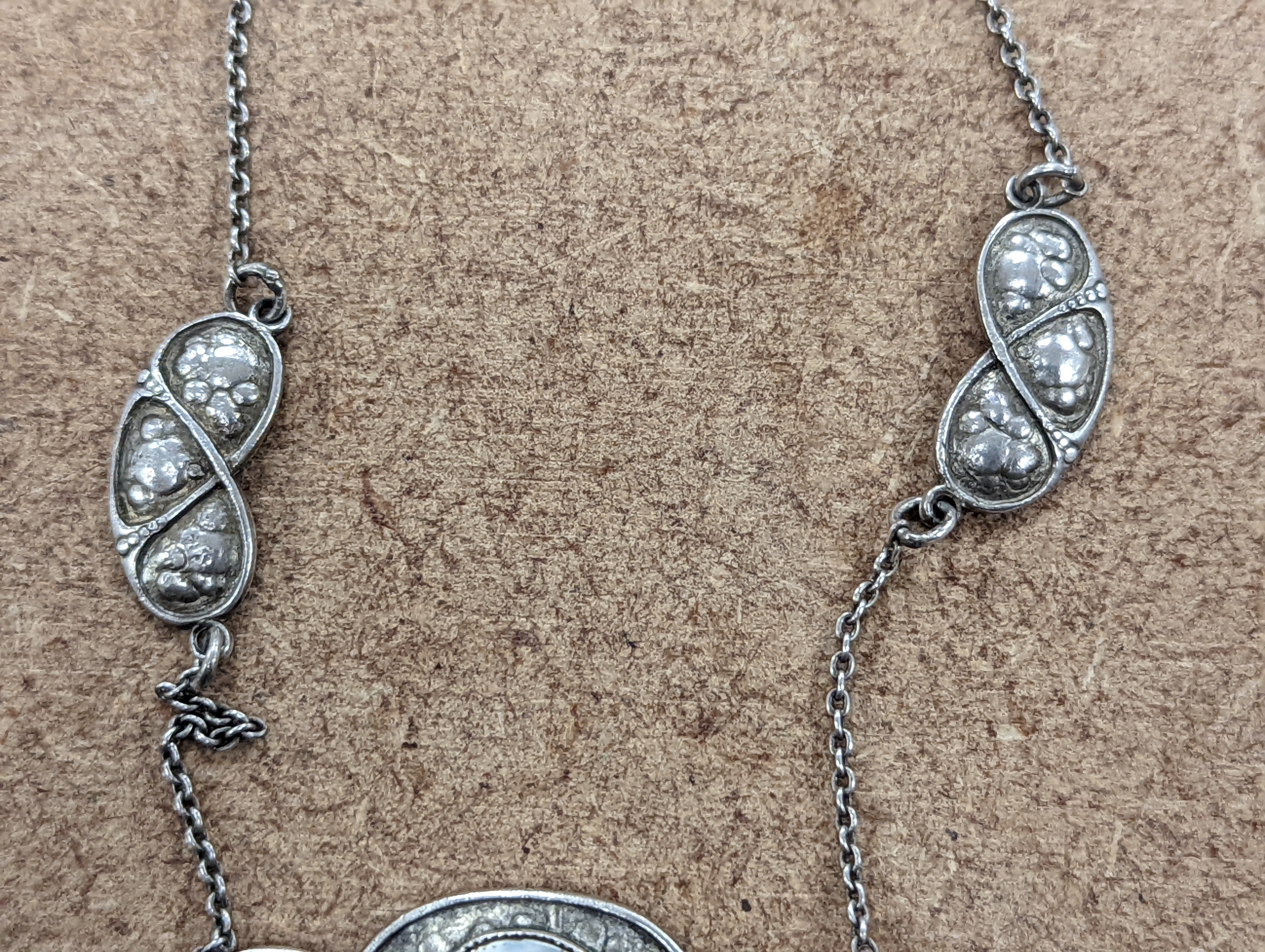 An Art Nouveau style sterling and mother of pearl set pendant necklace, stamped Queensway, 62cm and a white metal bangle.